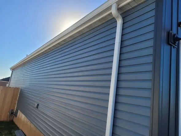 Finished siding run with straight courses and a properly routed downspout